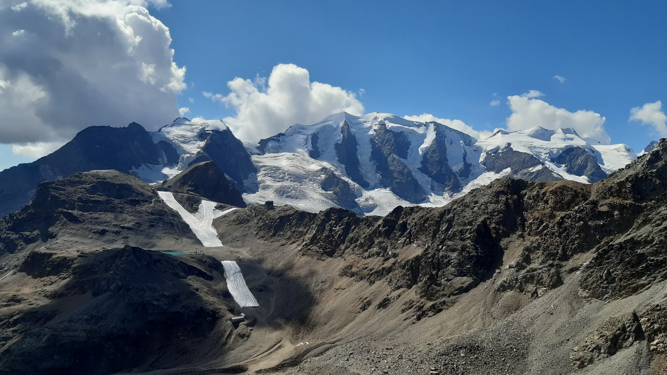 z_hrebeňa_pohľad_na_Diavolezzu,_prikrytý_sneh_na_zjazdovke,_v_pozadí_Palú